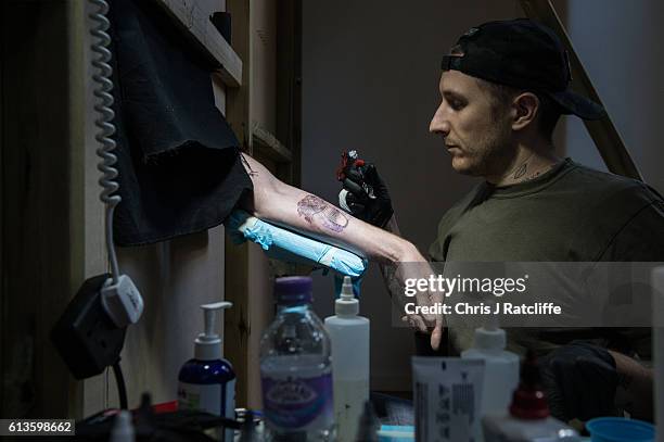 Cameron Ward has his first ever tattoo through a hole in the wall at celebrity tattoo artist Scott Campbell's event 'Whole Glory' on October 9, 2016...