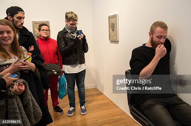 Cameron Ward has his first ever tattoo through a hole in the wall at celebrity tattoo artist Scott Campbell's event 'Whole Glory' on October 9, 2016...