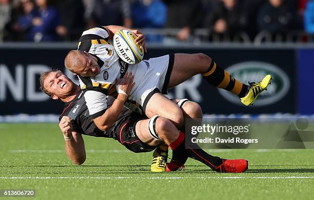 Tom Cruse of Wasps is tackled by Schalk Burger during the Aviva Premiership match between Saracens and Wasps at Allianz Park on October 9, 2016 in...