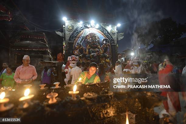 Nepali Hindu devotees pray in front the Hindu God Kaal Bhairav in Durbar Square during the Hindu Festival Dashain in Kathmandu on October 19, 2016....