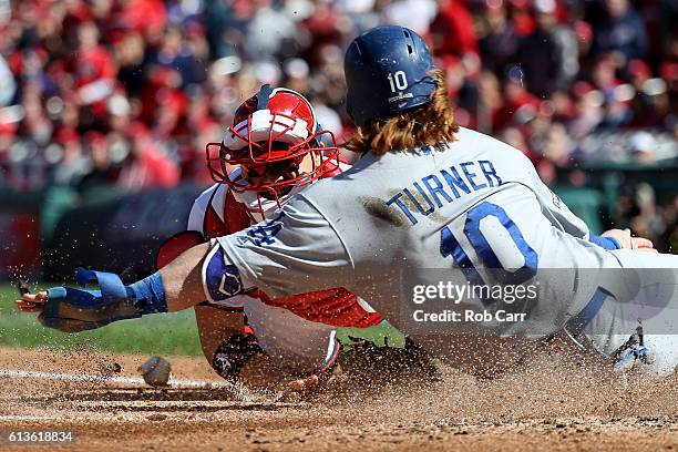 Justin Turner of the Los Angeles Dodgers scores against Jose Lobaton of the Washington Nationals on a single RBI hit by Josh Reddick of the Los...