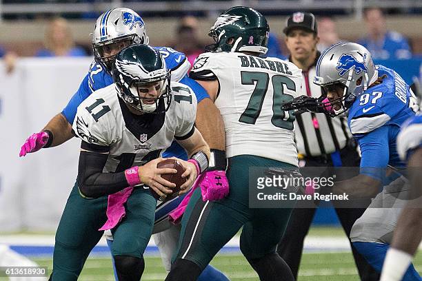 Quarterback Carson Wentz of the Philadelphia Eagles runs with the football past defensive end Armonty Bryant of the Detroit Lions during an NFL game...