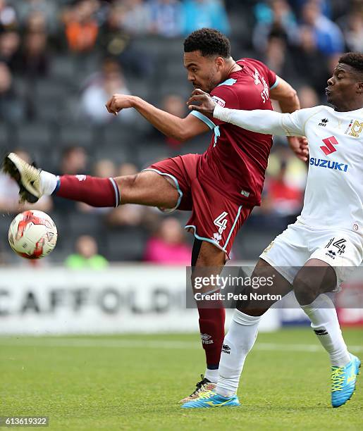 Remie Streete of Port Vale attempts to clear the ball under pressure from Kieran Agard of Milton Keynes Dons during the Sky Bet League One match...