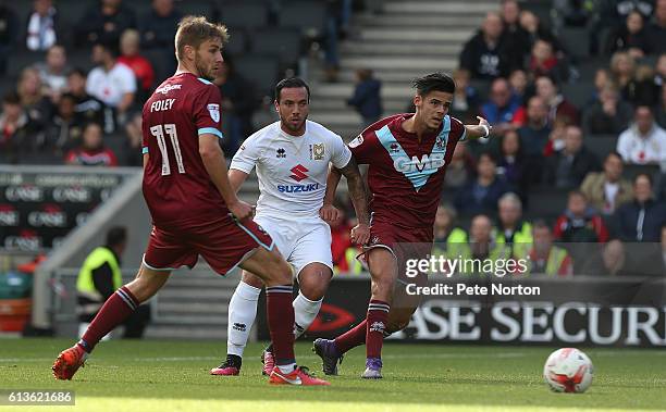 Samir Carruthers of Milton Keynes Dons moves forward with the ball past Sebastien Amoros and Sam Foley of Port Vale during the Sky Bet League One...