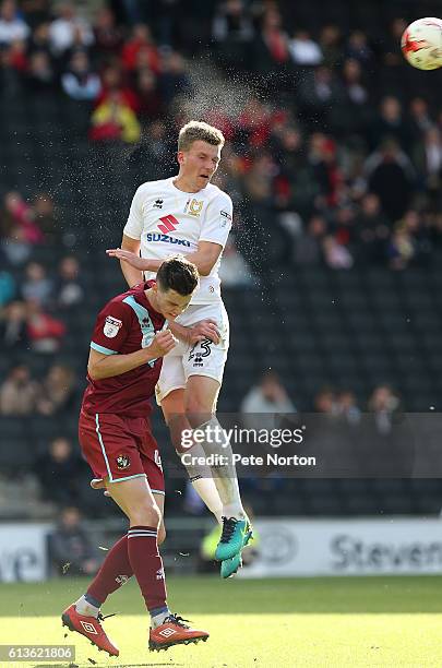 Paul Downing of Milton Keynes Dons rises to head the ball away from Sam Hart of Port Vale during the Sky Bet League One match between Milton Keynes...