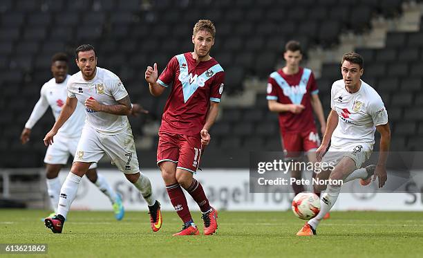 Sam Hart of Port Vale plays the ball watched by Samir Carruthers and Darren Potter of Milton Keynes Dons during the Sky Bet League One match between...