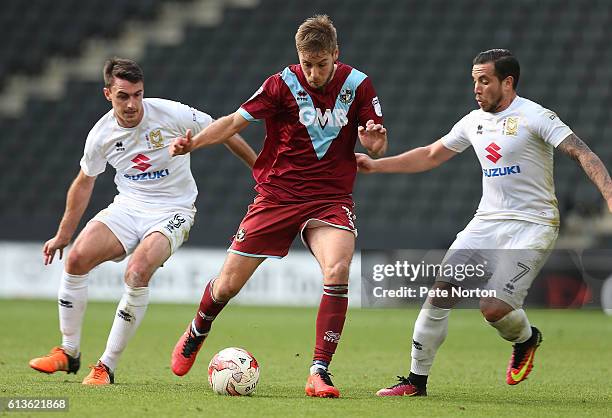 Sam Hart of Port Vale controls the ball watched by Samir Carruthers and Darren Potter of Milton Keynes Dons during the Sky Bet League One match...