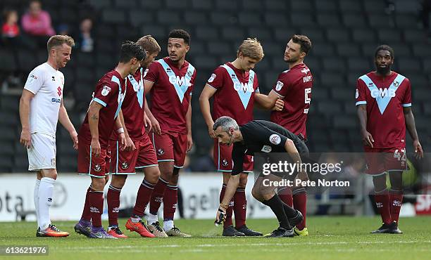 Referee Sebastian Stockbridge uses vanishing spray as Port Vale players line up to defend a free kick during the Sky Bet League One match between...