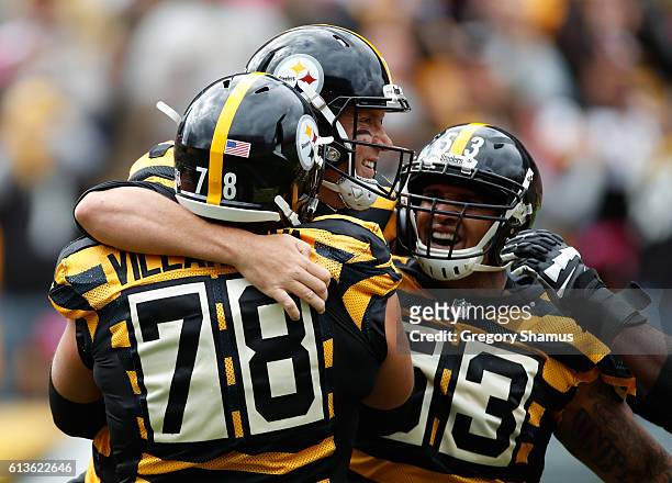 Ben Roethlisberger of the Pittsburgh Steelers celebrates a first quarter touchdown with Alejandro Villanueva and Maurkice Pouncey while playing the...