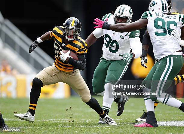 Le'Veon Bell of the Pittsburgh Steelers looks for running room during a second quarter run between Steve McLendon and Muhammad Wilkerson of the New...