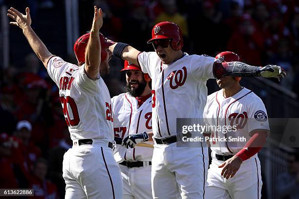 Jose Lobaton of the Washington Nationals celebrates with teammates Danny Espinosa, Tanner Roark, and Daniel Murphy after hitting a three run home run...