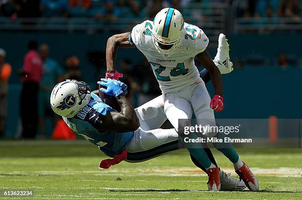 Delanie Walker of the Tennessee Titans makes a catch over Isa Abdul-Quddus of the Miami Dolphins during a game on October 9, 2016 in Miami Gardens,...