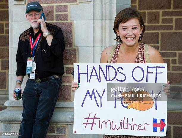 Student Breckan Erdman carries around a sign on the campus of Washington University in St, Louis, Missouri where the second presidential debate will...