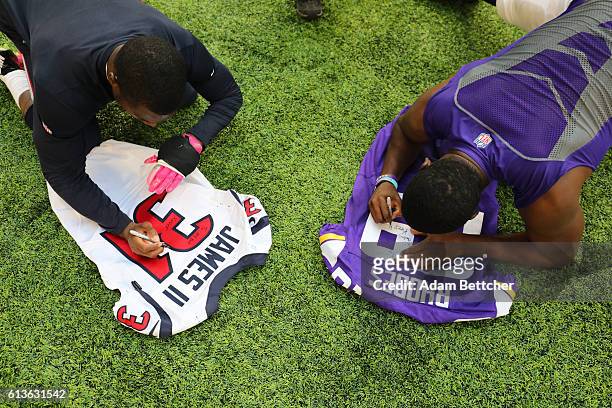 Charles James of the Houston Texans and Xavier Rhodes of the Minnesota Vikings autograph each others jerseys after the game on October 9, 2016 at US...