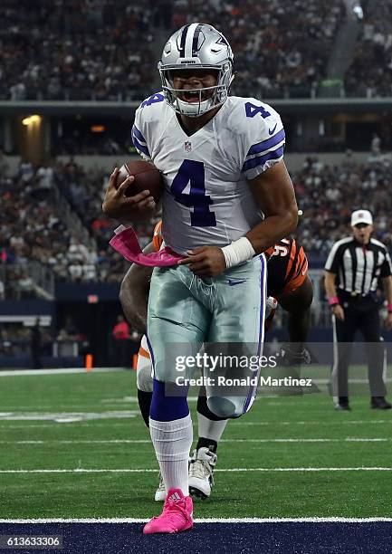 Dak Prescott of the Dallas Cowboys carries the ball into the end zone for a touchdown during the first half against the Cincinnati Bengals at AT&T...