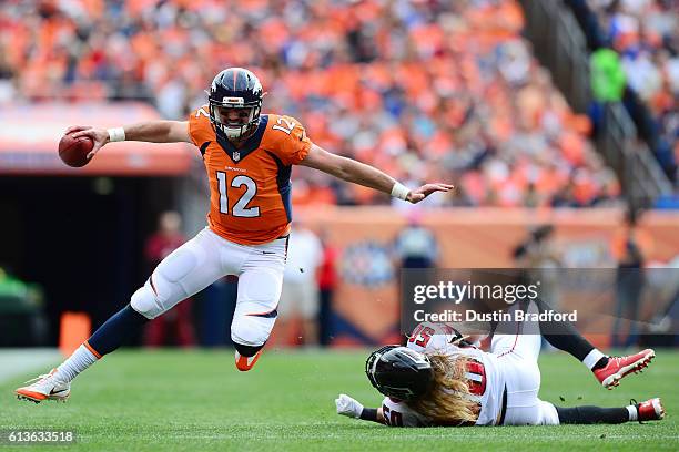 Quarterback Paxton Lynch of the Denver Broncos evades linebacker A.J. Hawk of the Atlanta Falcons in the first half of the game at Sports Authority...