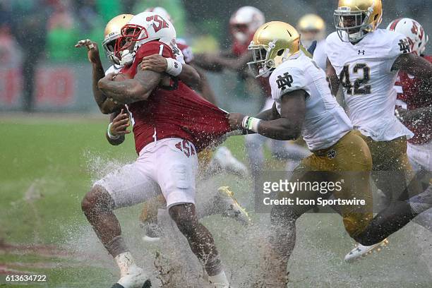 State Wolfpack fullback Jaylen Samuels runs the ball and is tackled by Notre Dame Fighting Irish cornerback Julian Love and Dexter Williams during...