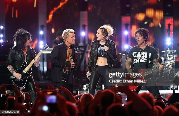 Guitarist Steve Stevens, singer Billy Idol, entertainer Miley Cyrus and guitarist Billy Morrison perform at the 2016 iHeartRadio Music Festival at...