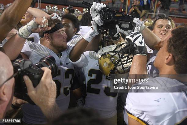 Purdue players celebrate with the Cannon trophy after a Big Ten Conference football game between the Purdue Boilermakers and the Illinois Fighting...