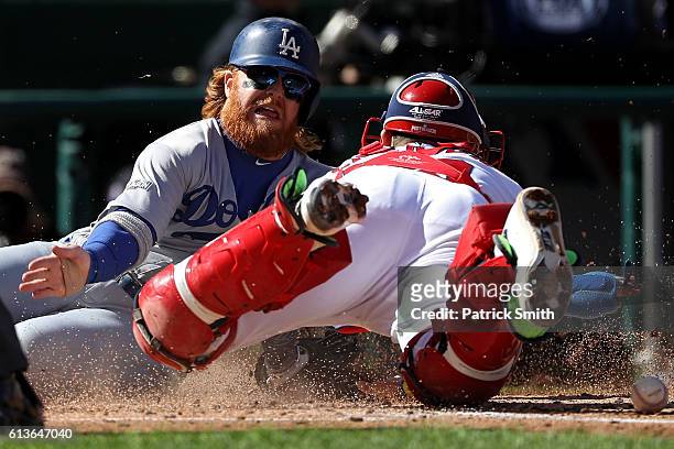 Justin Turner of the Los Angeles Dodgers scores against Jose Lobaton of the Washington Nationals on a single RBI hit by Josh Reddick of the Los...