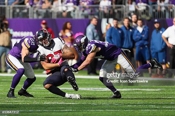 Tight end C.J. Fiedorowicz of the Houston Texans is tackled by free safety Harrison Smith of the Minnesota Vikings and Andrew Sendejo. The Minnesota...