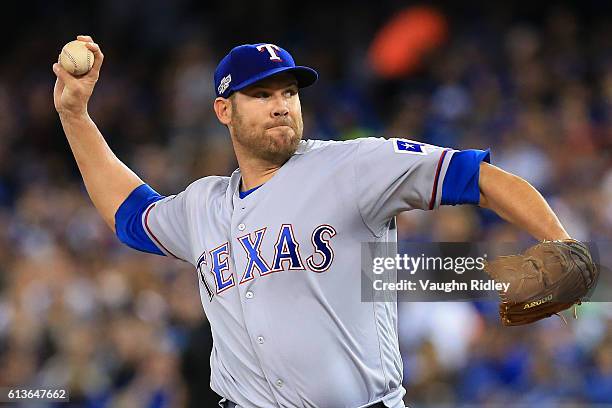 Colby Lewis of the Texas Rangers works against the Toronto Blue Jays in the first inning during game three of the American League Division Series at...