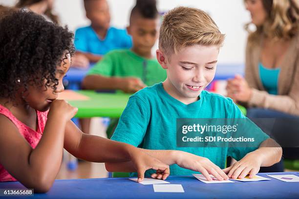 kindergartenkinder spielen mit blitzkarten - leselernkarte stock-fotos und bilder