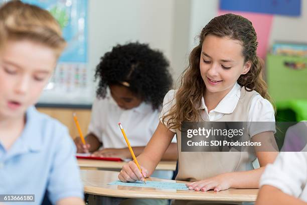 studious schoolgirl takes test in science class - studious girl 個照片及圖片檔