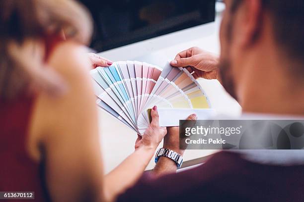 innenarchitekten, die auf farbdiagramme zeigen - farbfächer stock-fotos und bilder