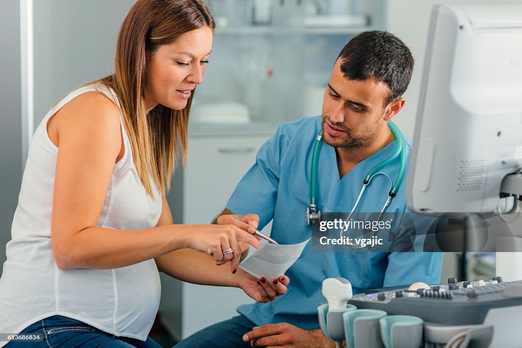 Pregnant Woman And Male Doctor In A Consultation.