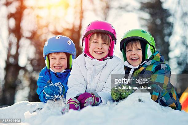 happy kids de ski de toutes les tenues d'hiver - stage sportif photos et images de collection