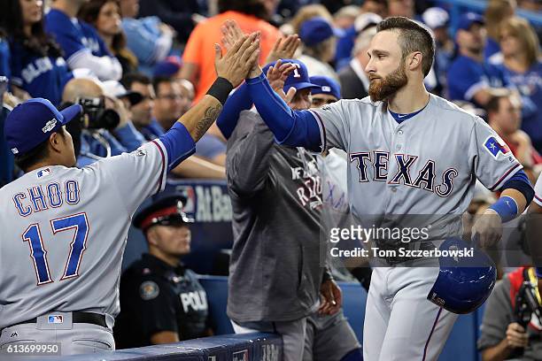 Jonathan Lucroy of the Texas Rangers celebrates with teammate Shin-Soo Choo after scoring on a two run double hit by Mitch Moreland in the sixth...
