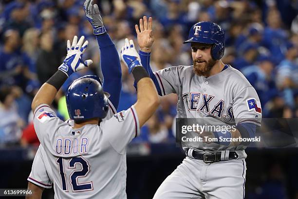 Jonathan Lucroy of the Texas Rangers celebrates with teammate Rougned Odor after scoring on a two run double hit by Mitch Moreland in the sixth...