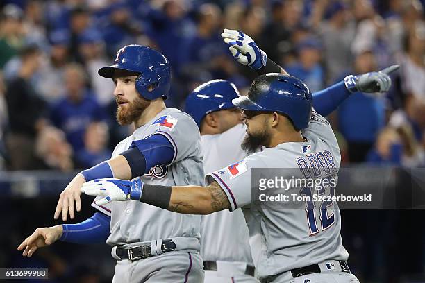 Jonathan Lucroy of the Texas Rangers celebrates with teammate Rougned Odor after scoring on a two run double hit by Mitch Moreland in the sixth...