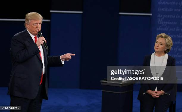 Republican presidential candidate Donald Trump speaks as US Democratic presidential candidate Hillary Clinton listens during the second presidential...