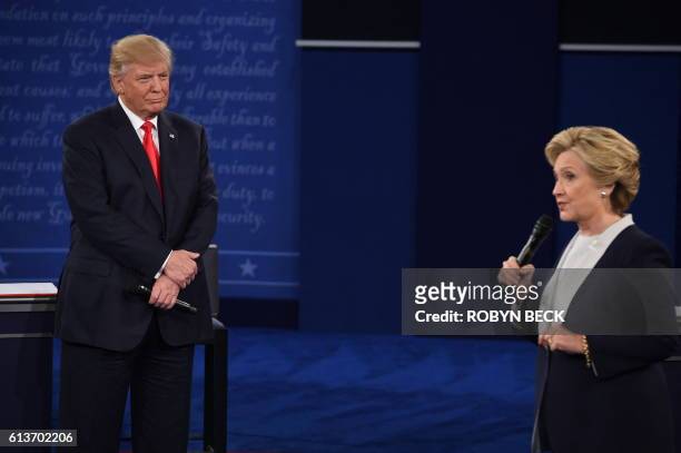Republican presidential candidate Donald Trump listens to US Democratic presidential candidate Hillary Clinton during the second presidential debate...