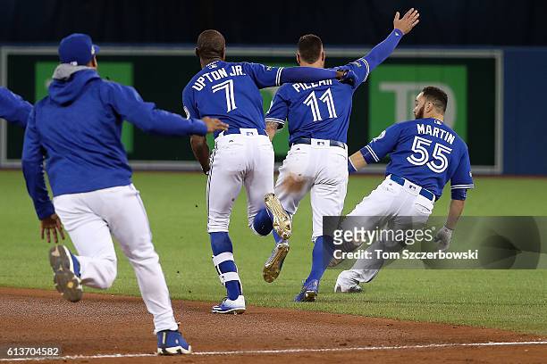 Melvin Upton Jr. #7 and Kevin Pillar of the Toronto Blue Jays chase after teammate Russell Martin after the Toronto Blue Jays defeated the Texas...