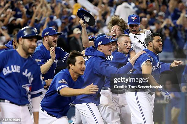 The Toronto Blue Jays celebrate after defeating the Texas Rangers 7-6 in ten innings during game three of the American League Division Series at...