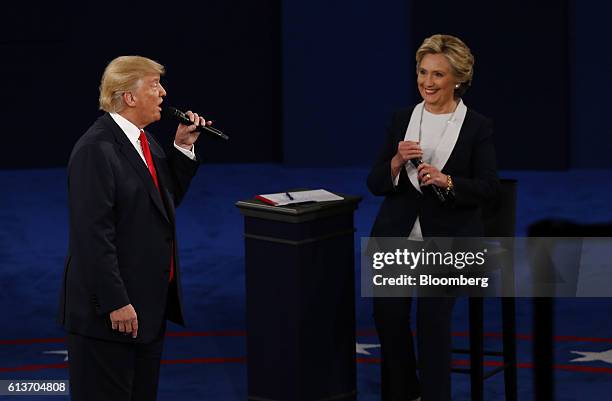 Donald Trump, 2016 Republican presidential nominee, speaks as Hillary Clinton, 2016 Democratic presidential nominee, smiles during the second U.S....