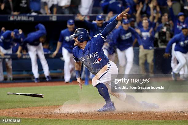 Josh Donaldson of the Toronto Blue Jays celebrates after sliding safely into home plate in the tenth inning for the Toronto Blue Jays to defeat the...