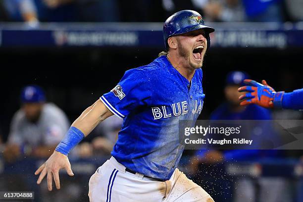 Josh Donaldson of the Toronto Blue Jays celebrates after sliding safely into home plate in the tenth inning for the Toronto Blue Jays to defeat the...