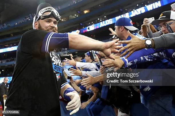 Russell Martin of the Toronto Blue Jays celebrates with fans after the Toronto Blue Jays defeated the Texas Rangers for game three of the American...