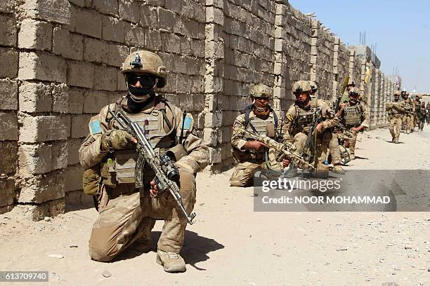 In this photograph taken on October 9 Afghan National Army commandos take position during a military operation in Helmand province. / AFP / NOOR...