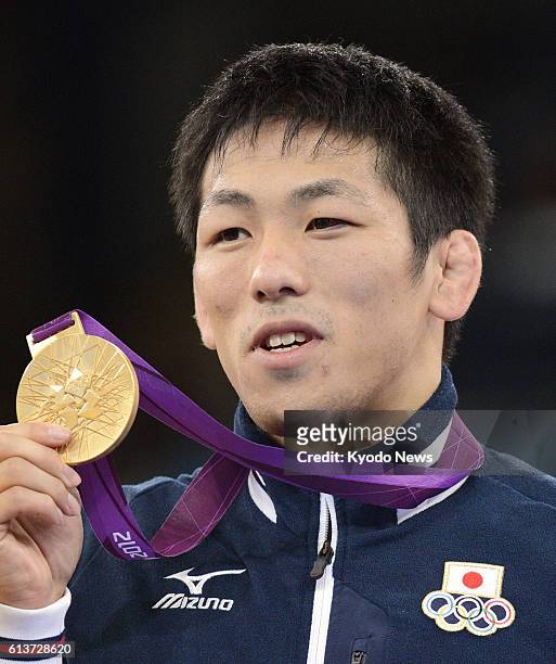 Britain - Japan's Tatsuhiro Yonemitsu smiles with the gold medal he won in the men's 66 kilogram freestyle wrestling at the 2012 London Olympics at...