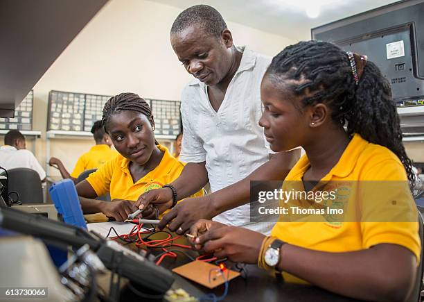 Accra, Ghana Girls Vocational Training Institute, a vocational school for girls. Here, an instructor teaches two African girls in electrical...