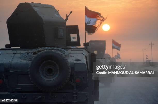 Pro-government forces drive in military vehicles in Iraq's eastern Salaheddin province, south of Hawijah, on October 10 as they clear the area in...