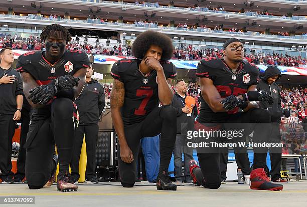 Eli Harold, Colin Kaepernick, and Eric Reid of the San Francisco 49ers kneel in protest during the national anthem prior to their NFL game against...