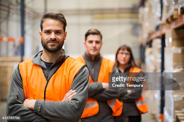 warehouse workers portrait in work overalls - reflecterende kleren stockfoto's en -beelden