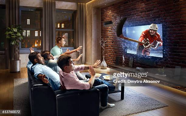 students watching very realistic ice hockey game on tv - shooting puck stock pictures, royalty-free photos & images