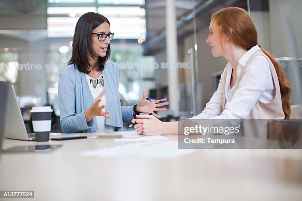 coaching and advise, two business woman working together. - demonstrating imagens e fotografias de stock